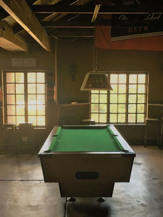 The pool table in afternoon light from the windows