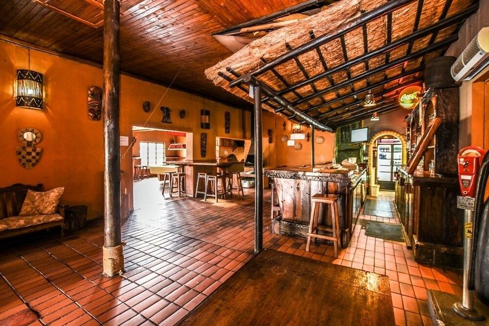 The bar seen from the entrance, with a thatched canopy over the counter and the games room beyond