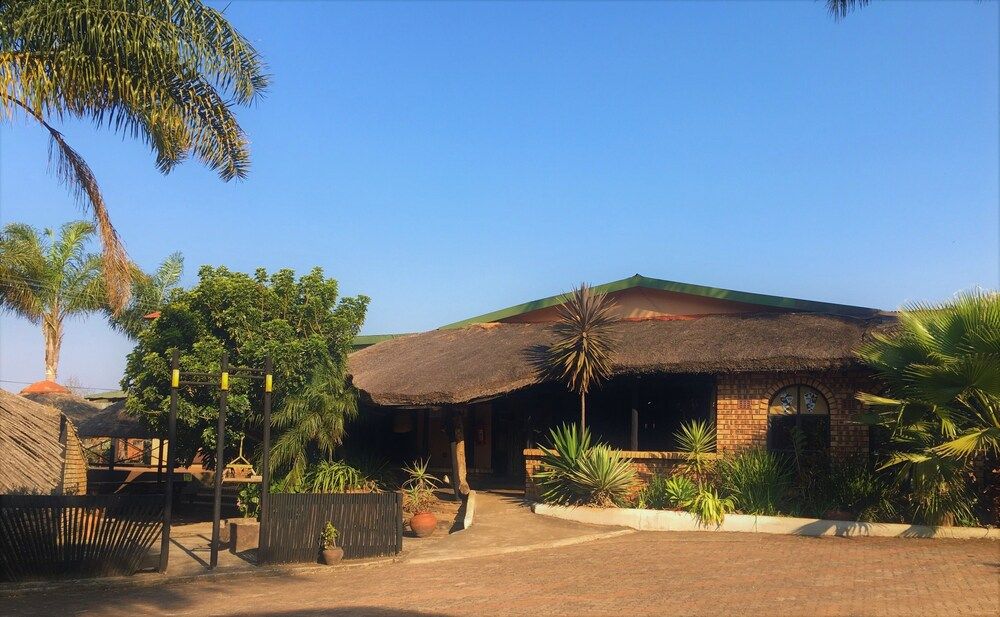 The thatched restaurant and pub building at Summit Lodge, with parking in front